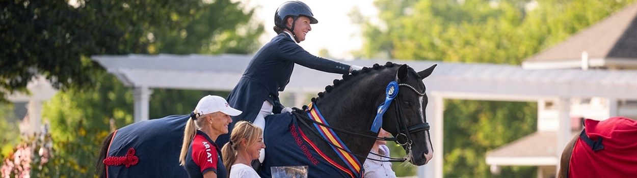Sabine Schut-Kery in the winner's circle aboard her black stallion